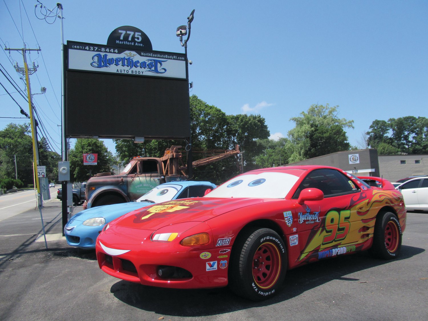 NORTHEAST NICHE: Lightning McQueen, Sally, and Mater are just three of the uniquely detailed vehicles at the 775 Hartford Ave. entrance to Northeast Auto Body, in Johnston. Kids often ask their parents and grandparents to stop for photos with the life-size animated characters come to life.